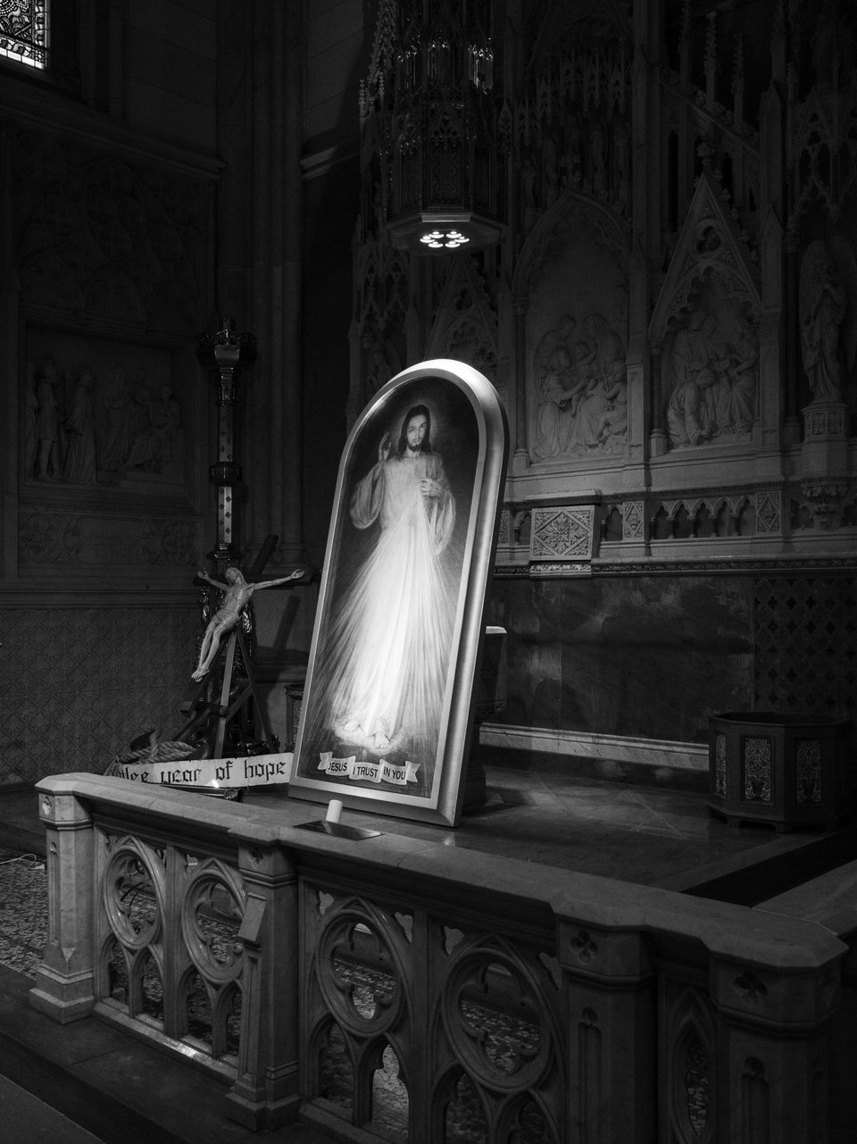 A luminous devotional portrait in the dark interior of a church