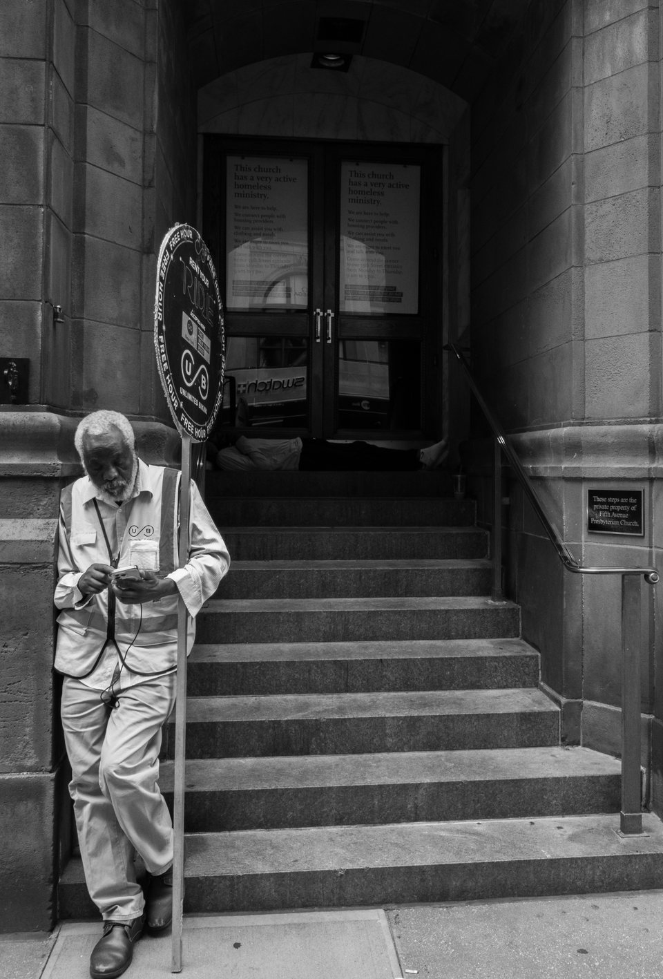 An older person with a cane standing on stone steps