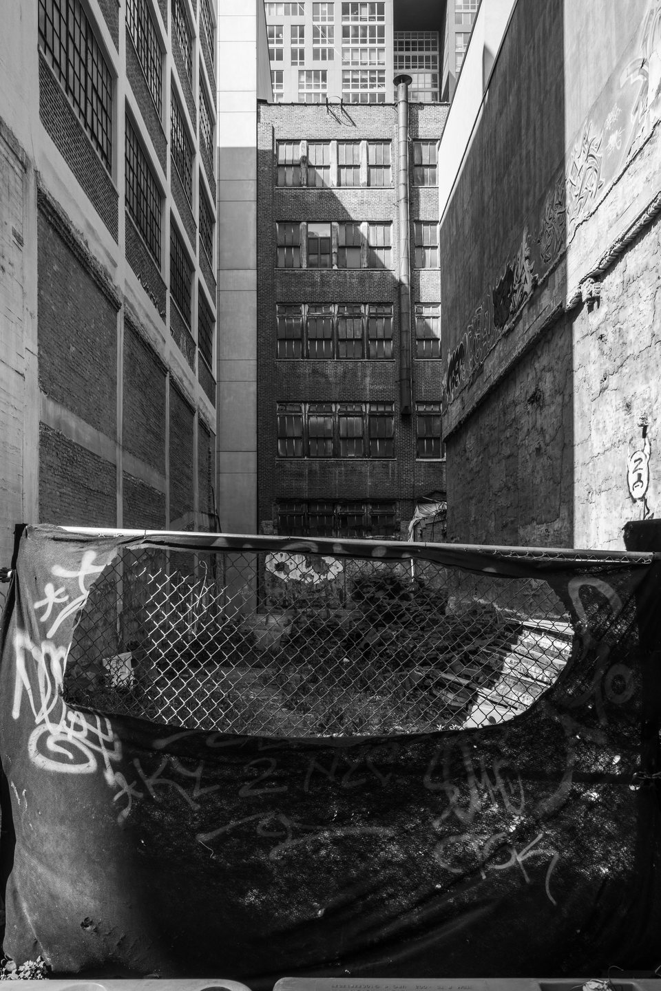A discarded sofa wedged in a narrow graffiti-covered alley