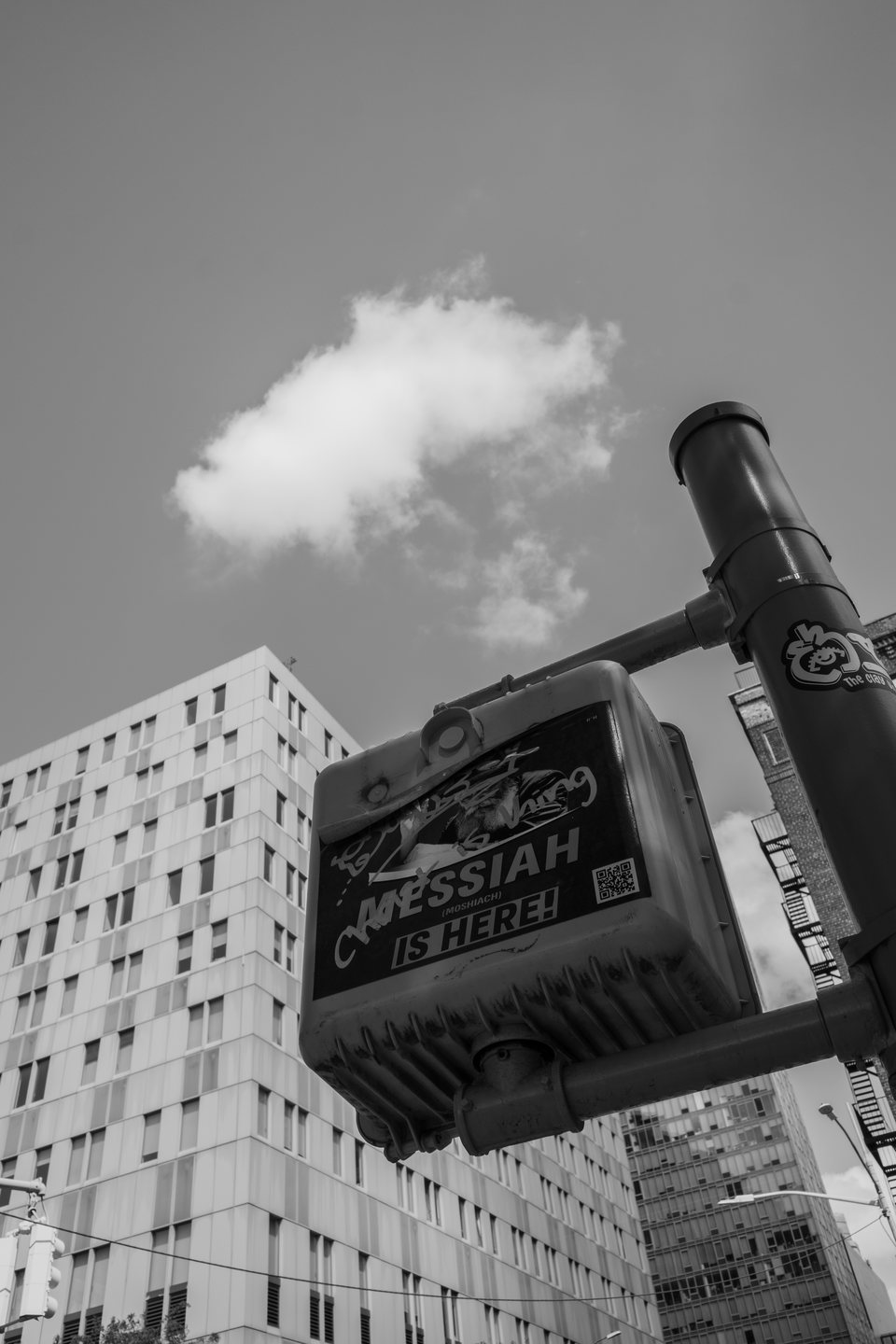 A small cloud above a rooftop chimney and a hand-painted sign