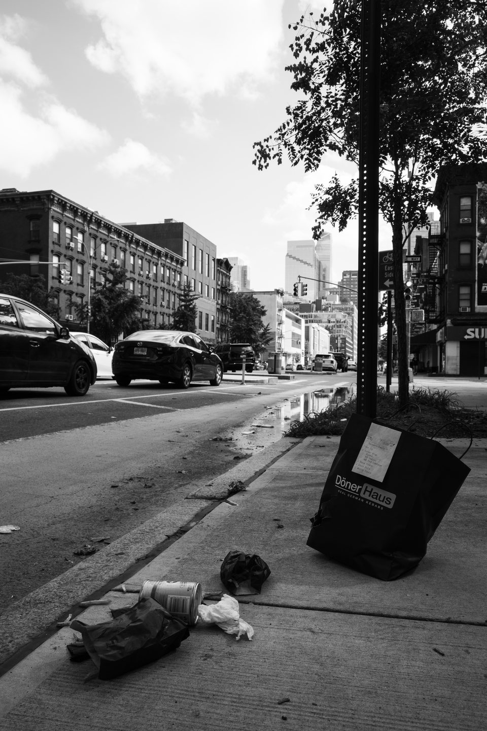 Discarded bags and objects scattered along a city sidewalk