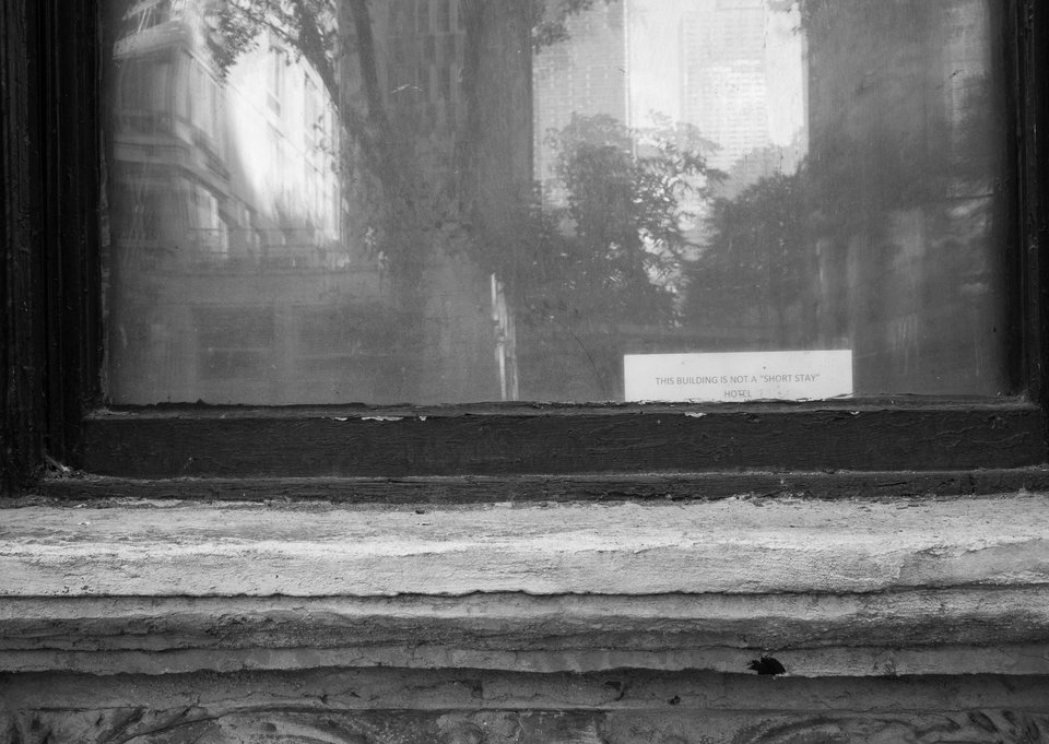 A blurred reflection in a weathered street-level window