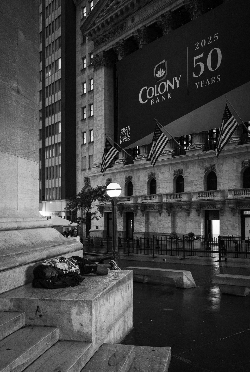 A person lying beneath an awning outside a bank