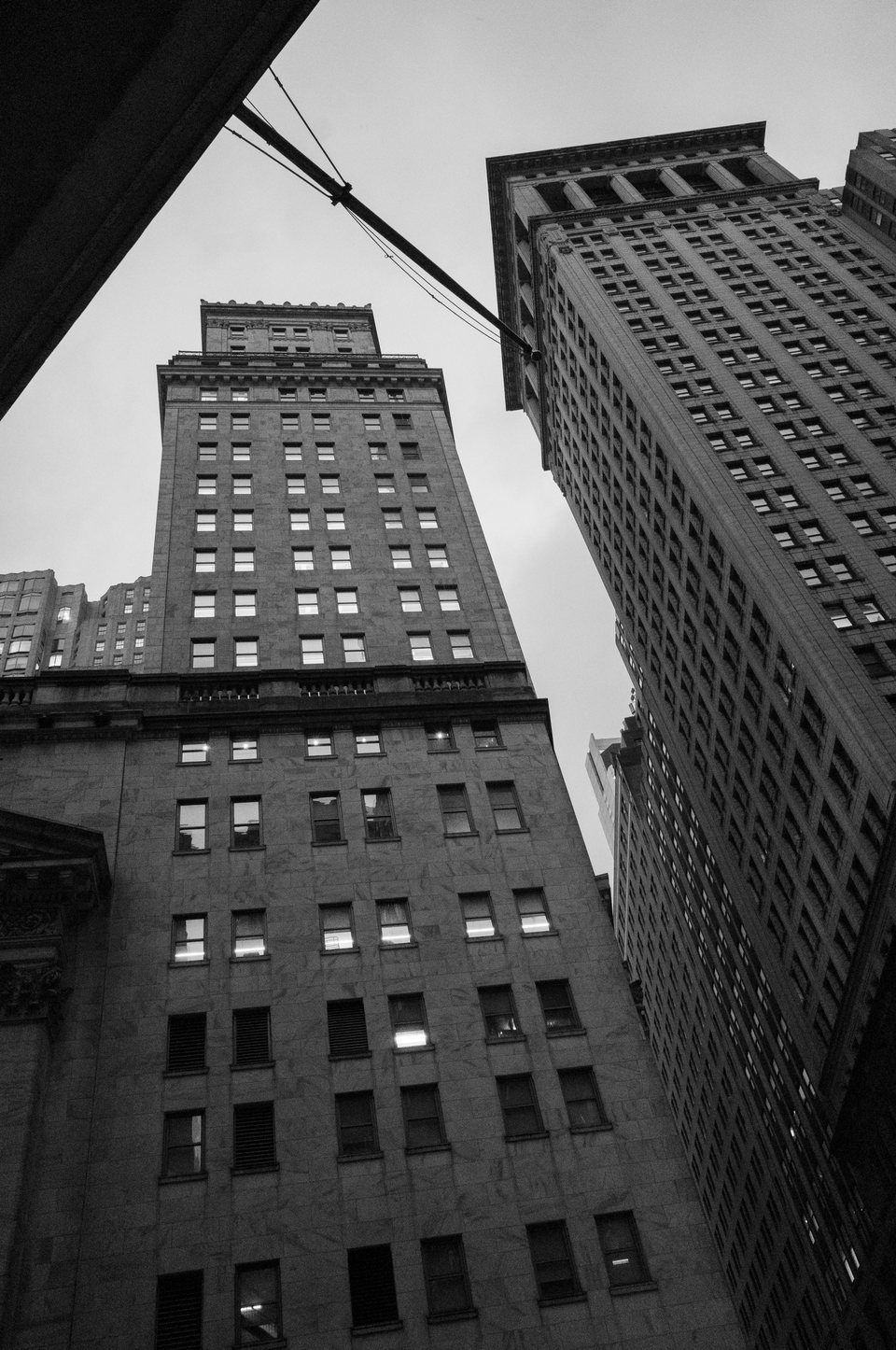Tall stone buildings seen from a narrow street below